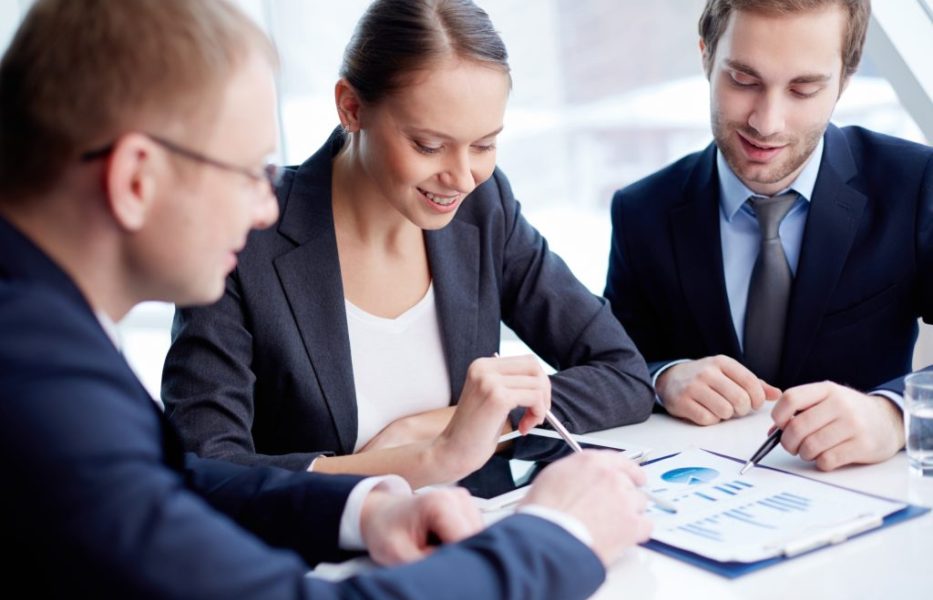 co-workers-with-pens-pointing-bar-chart (1)